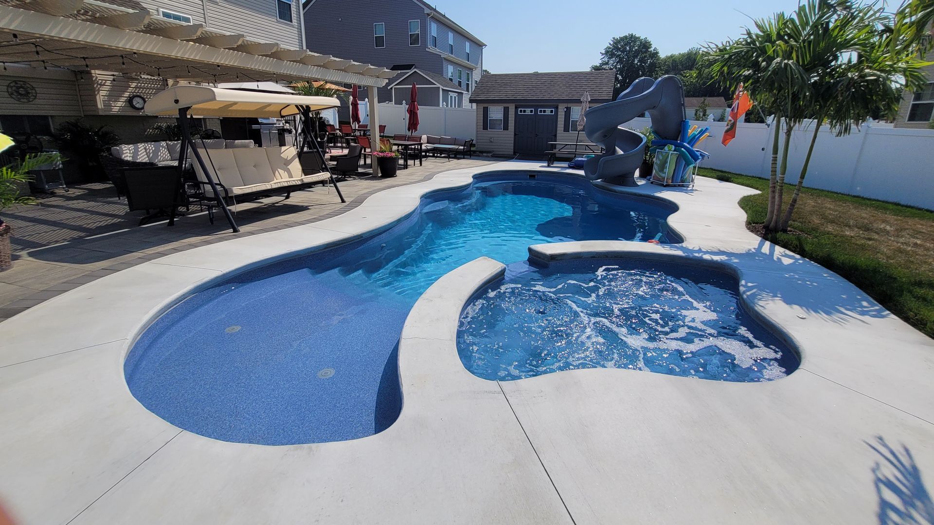 A large swimming pool with a slide in the backyard
