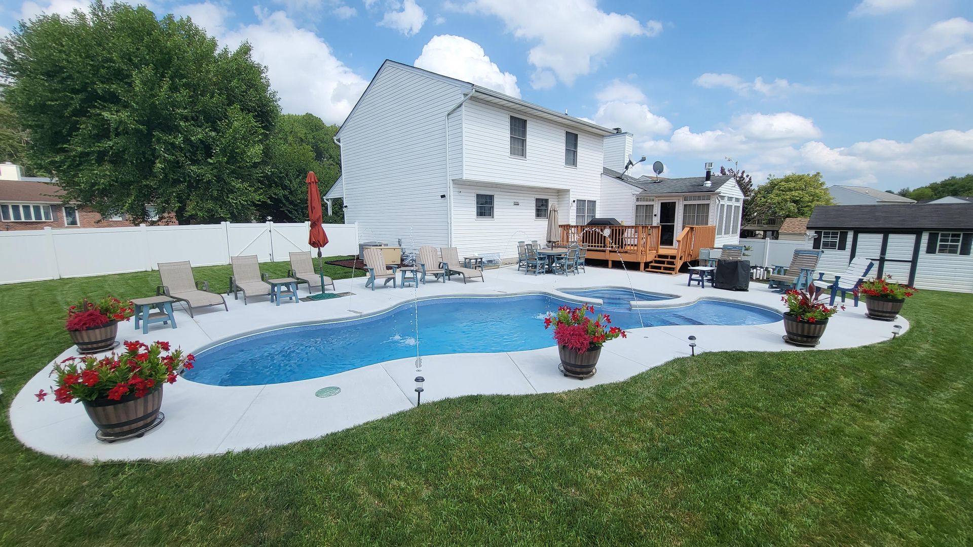There is a large swimming pool in the backyard of a house.