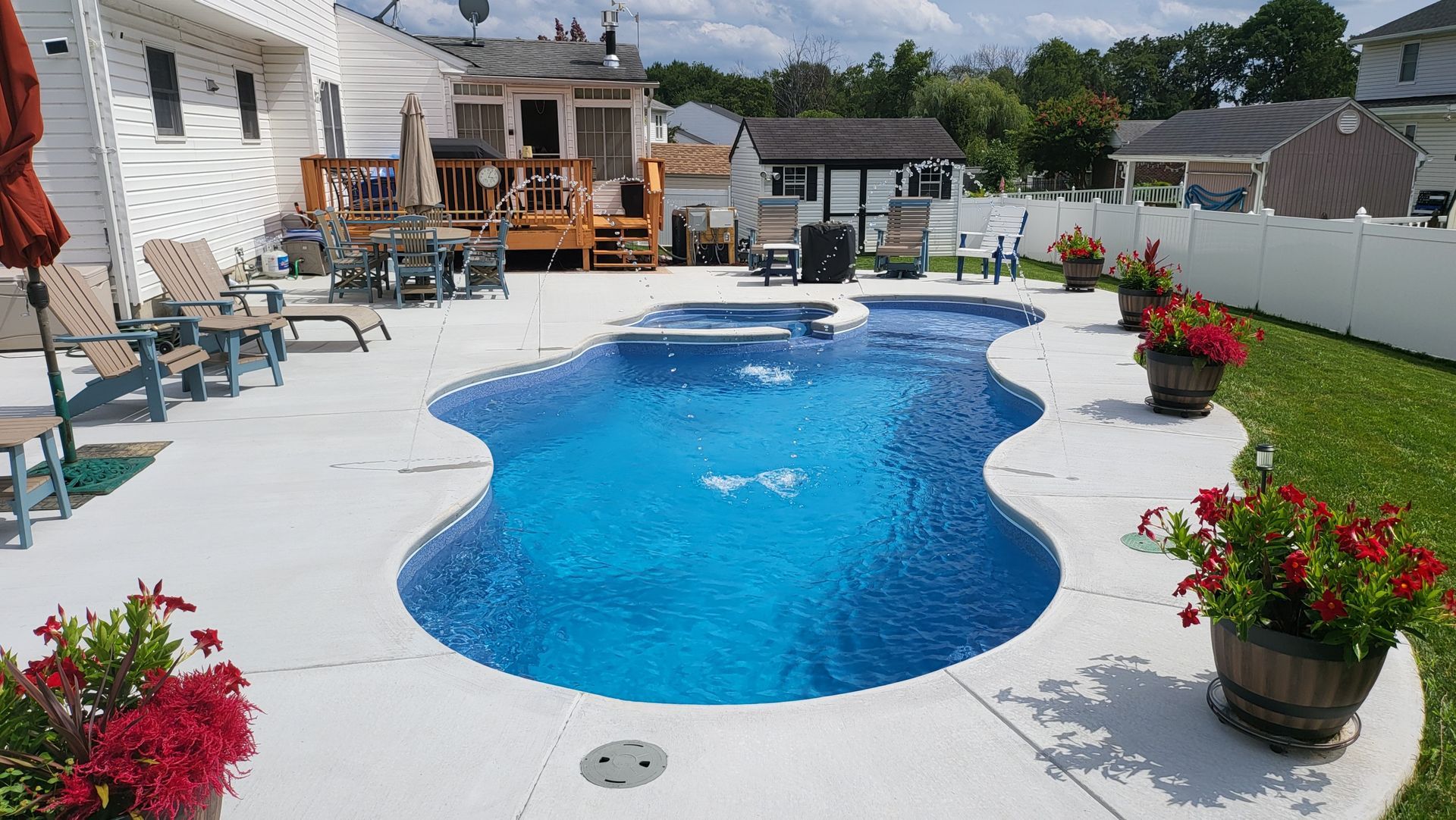 A large swimming pool is in the backyard of a house.