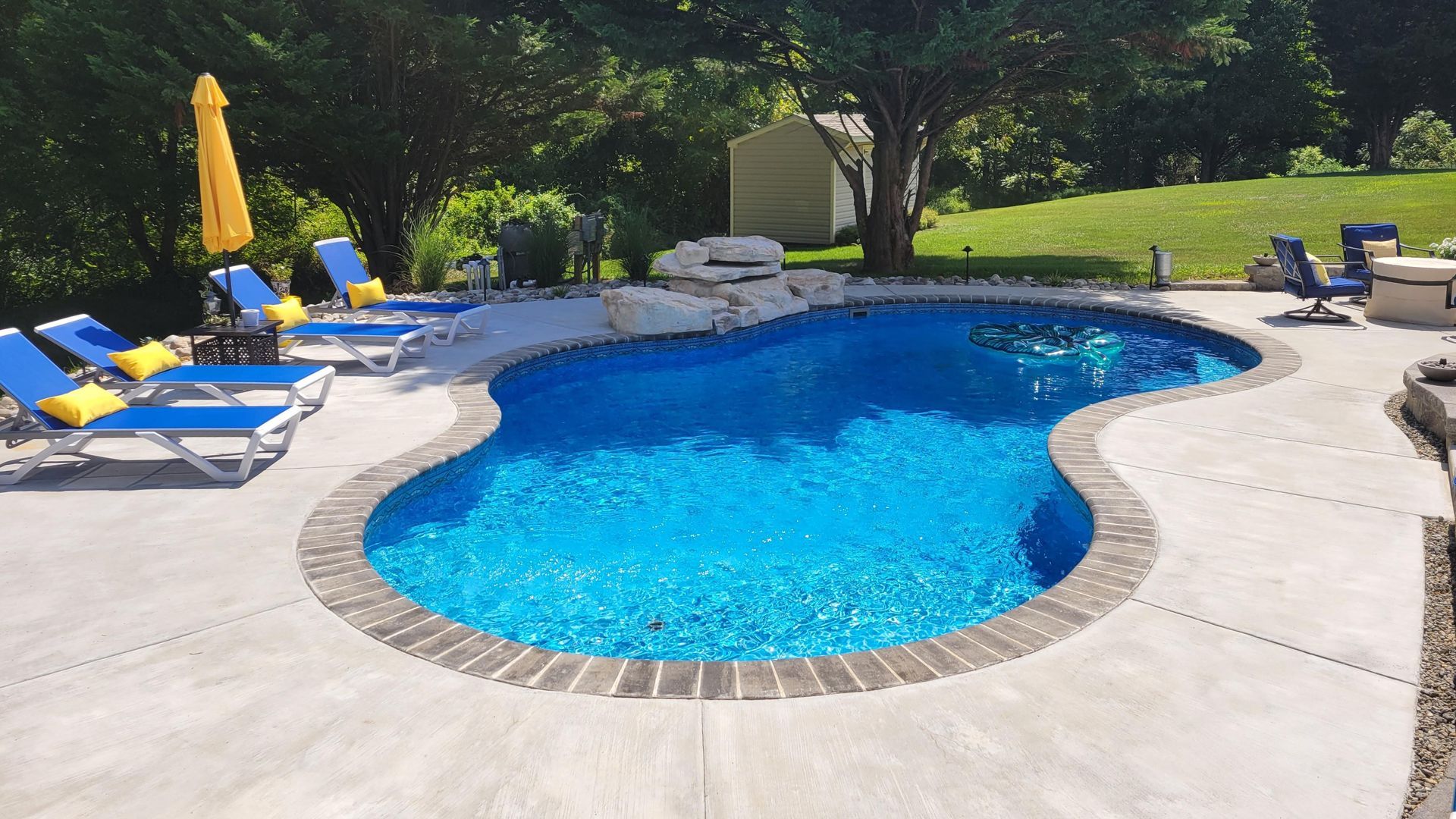 A large swimming pool surrounded by chairs and umbrellas