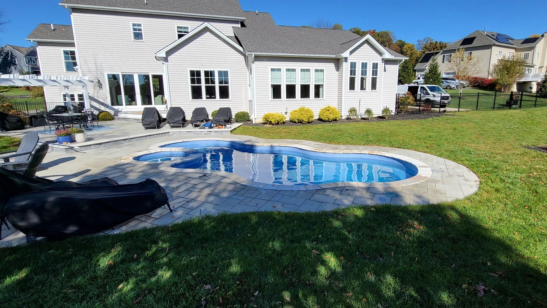 A large white house with a large swimming pool in front of it.