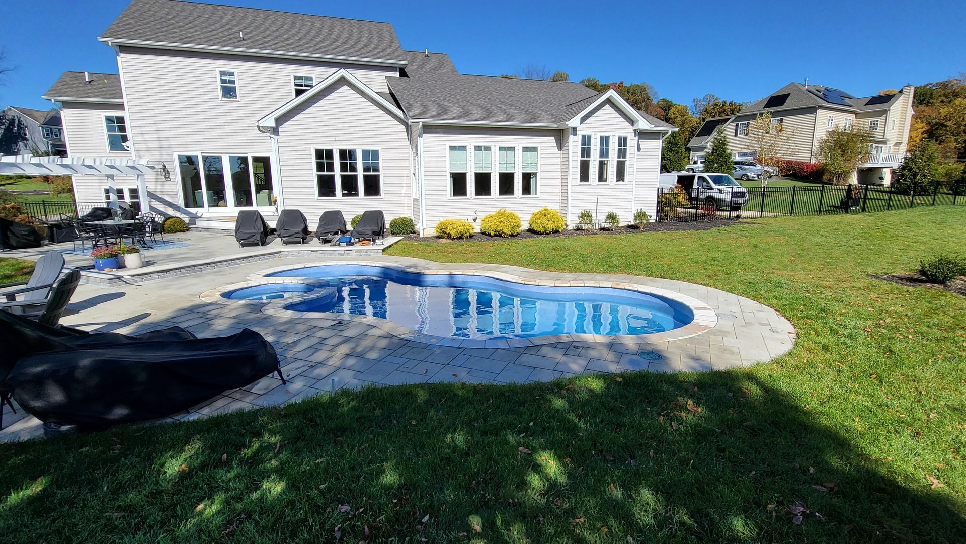 A large white house with a large swimming pool in front of it.