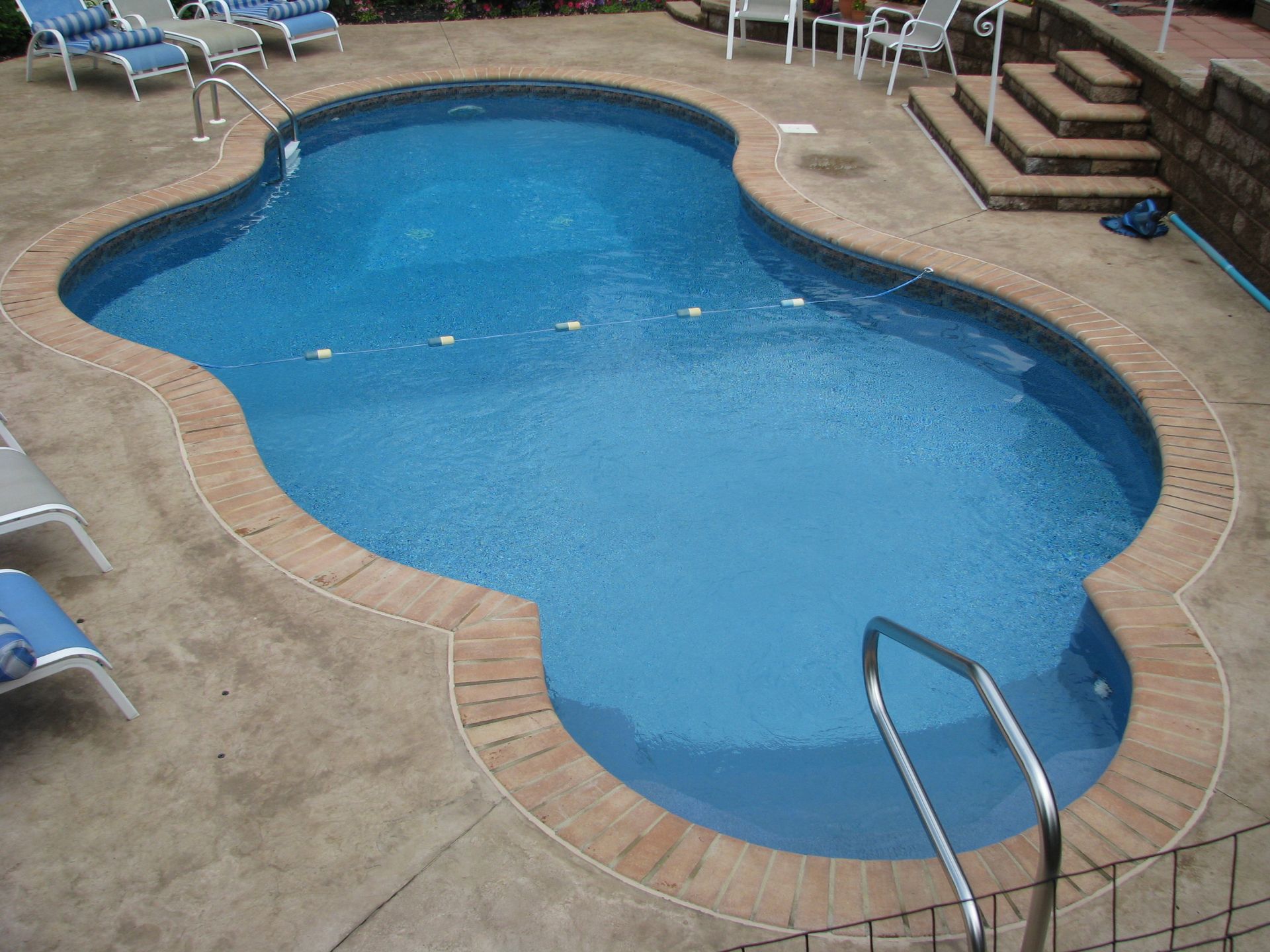 A large swimming pool surrounded by chairs and stairs