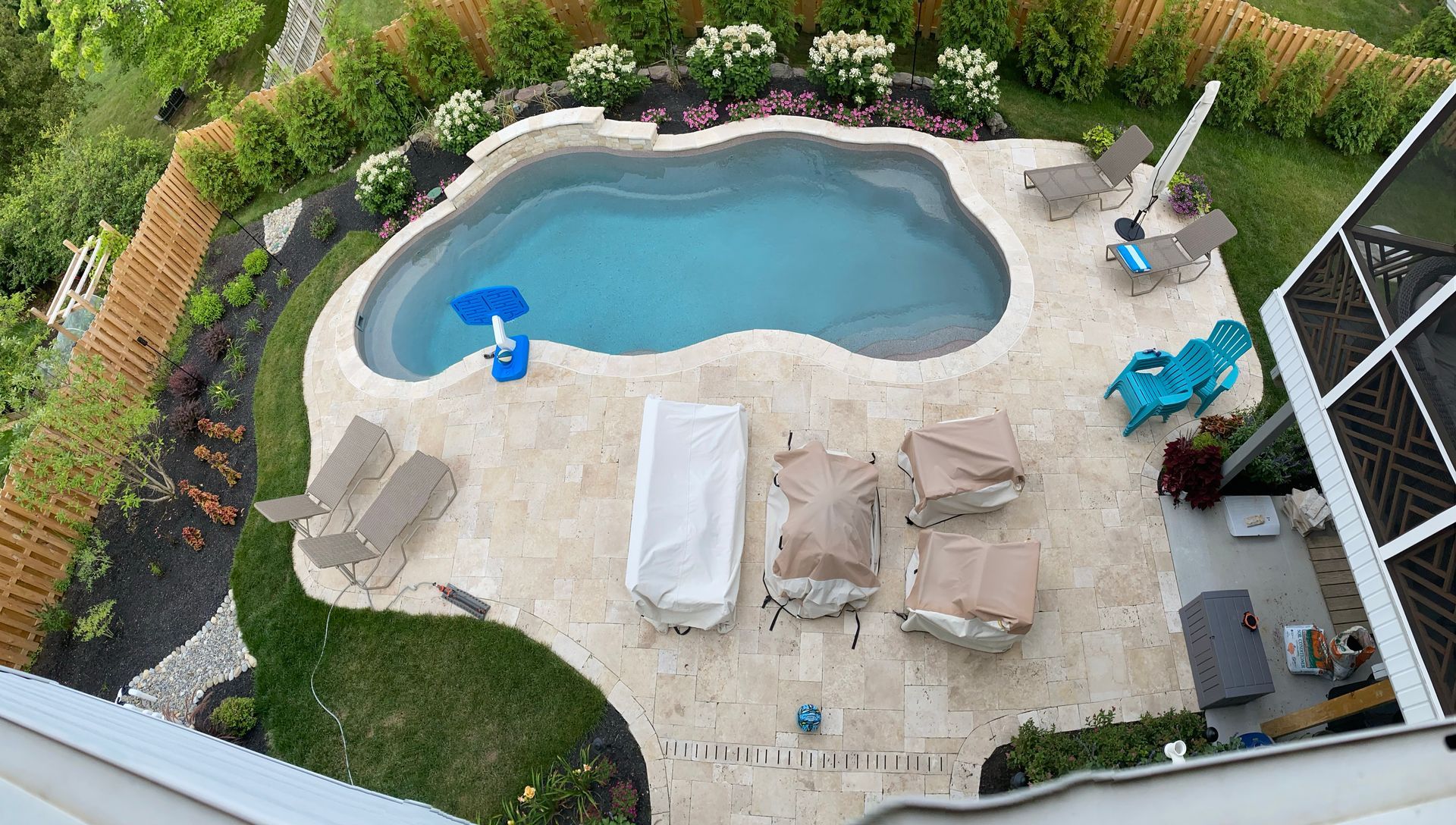 An aerial view of a large swimming pool surrounded by chairs and a fence.