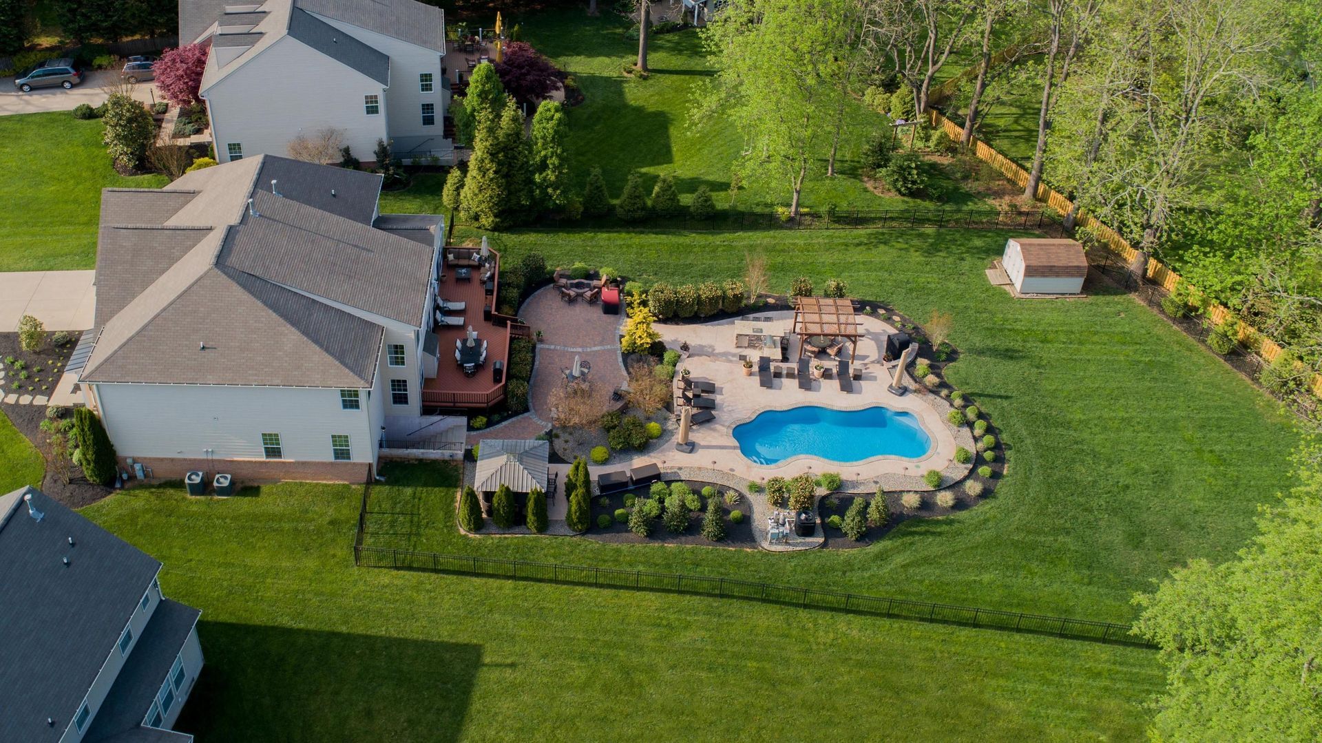 An aerial view of a house with a large swimming pool in the backyard.