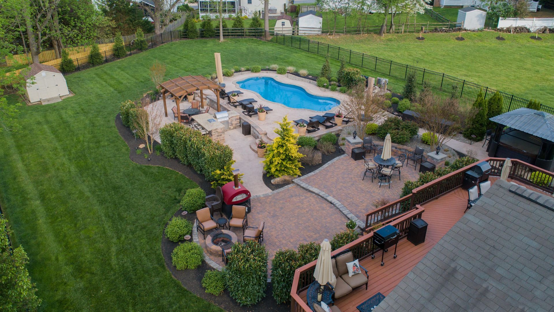 An aerial view of a large backyard with a swimming pool and patio area.