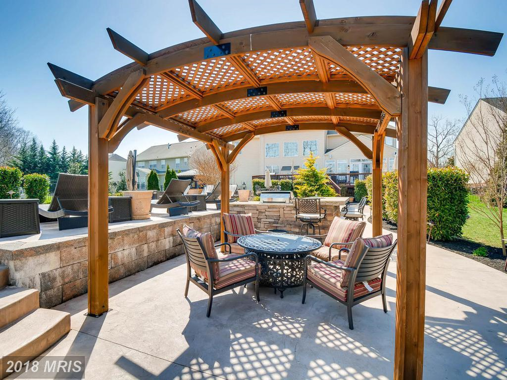 A pergola with a table and chairs underneath it