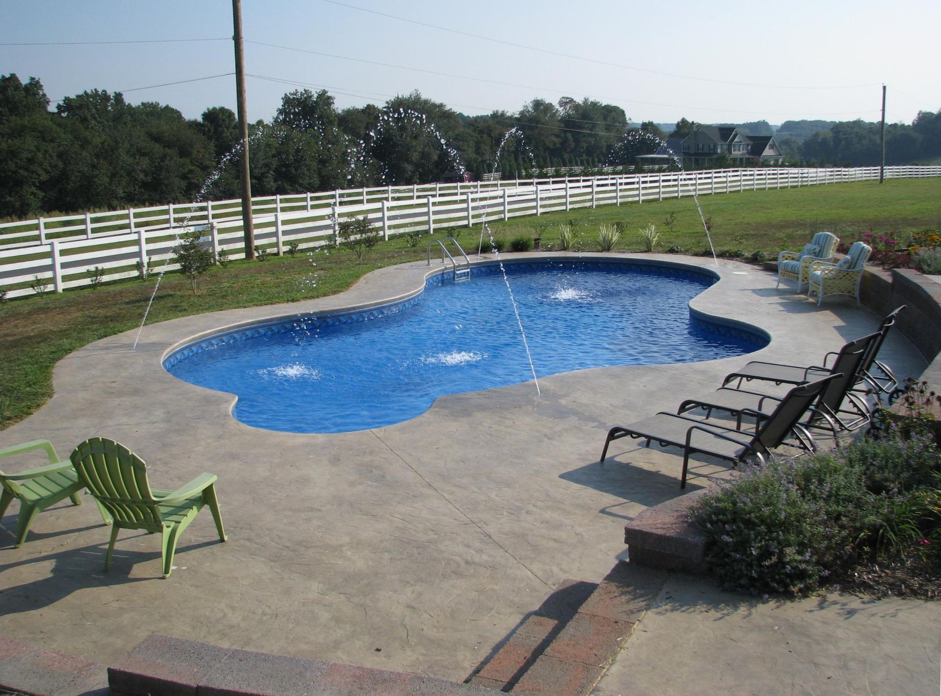 A swimming pool with a fountain in the middle of it