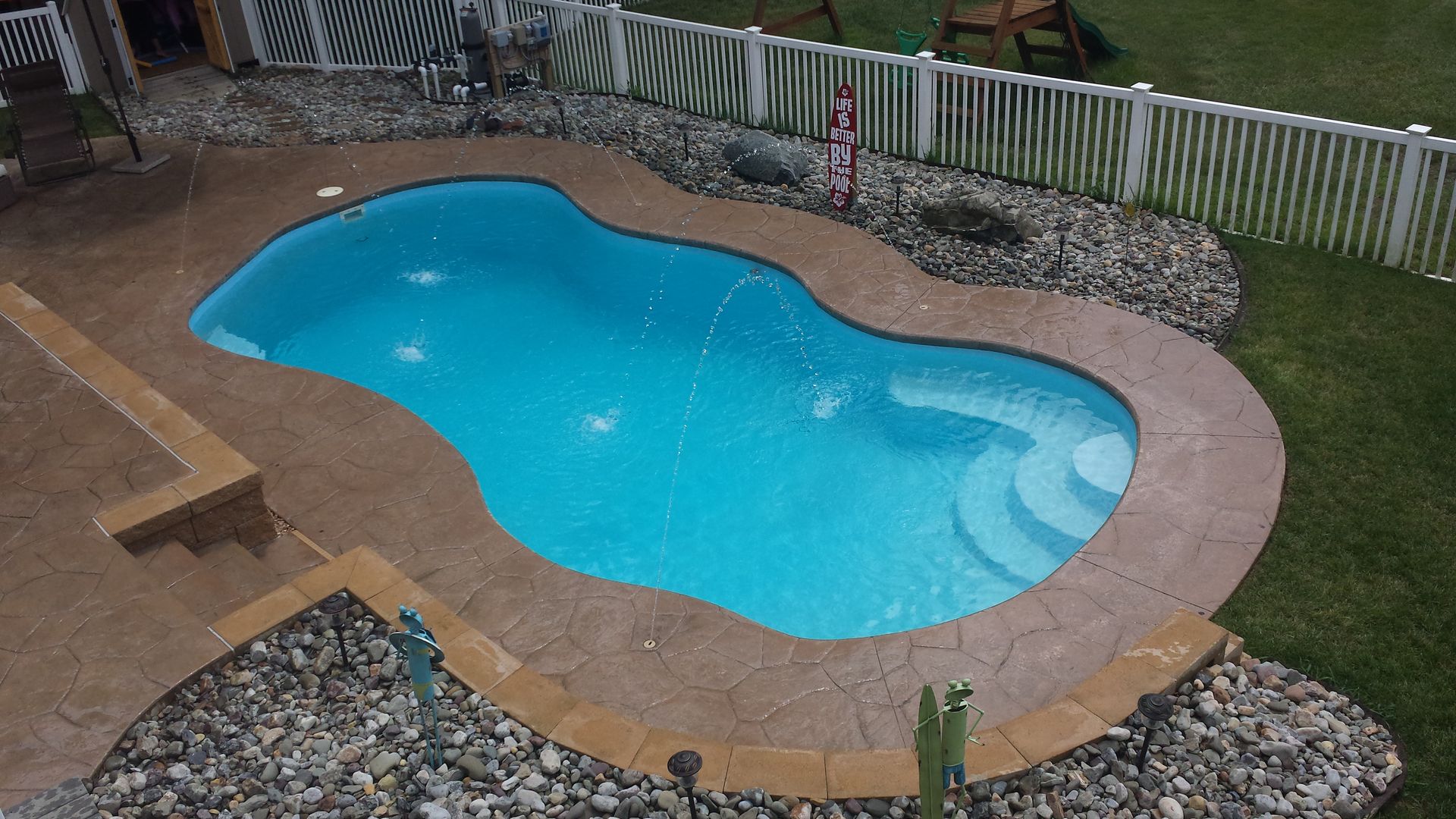 An aerial view of a swimming pool in a backyard.