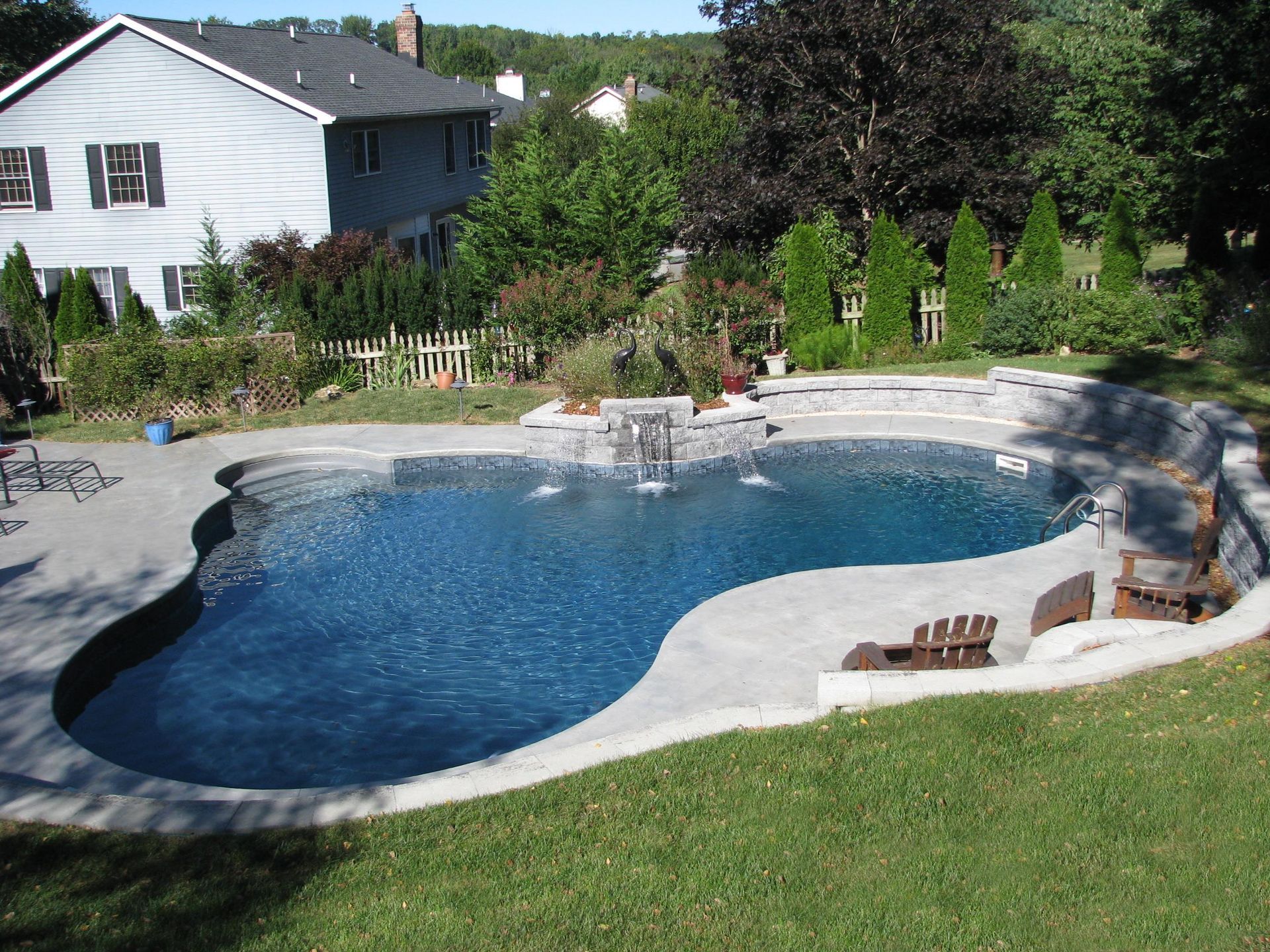 A large swimming pool with a house in the background