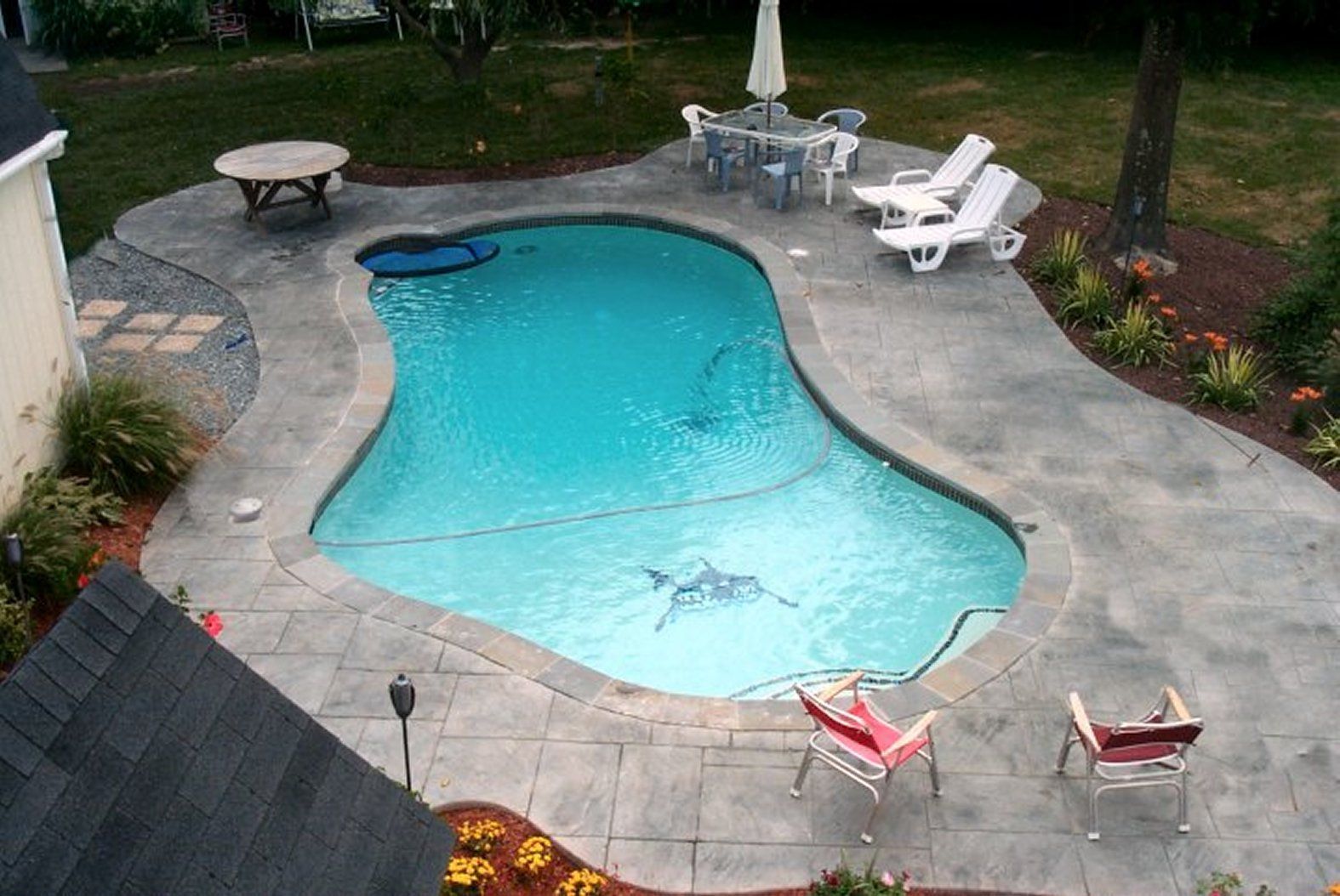An aerial view of a large swimming pool surrounded by chairs and tables