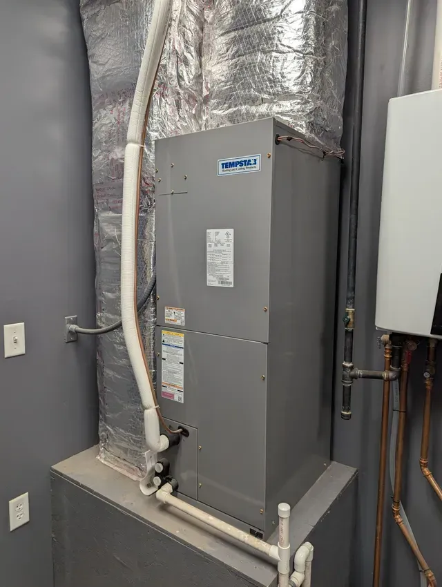 An air conditioner is sitting on top of a shelf in a room.