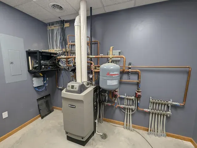 A room with a boiler and pipes in it