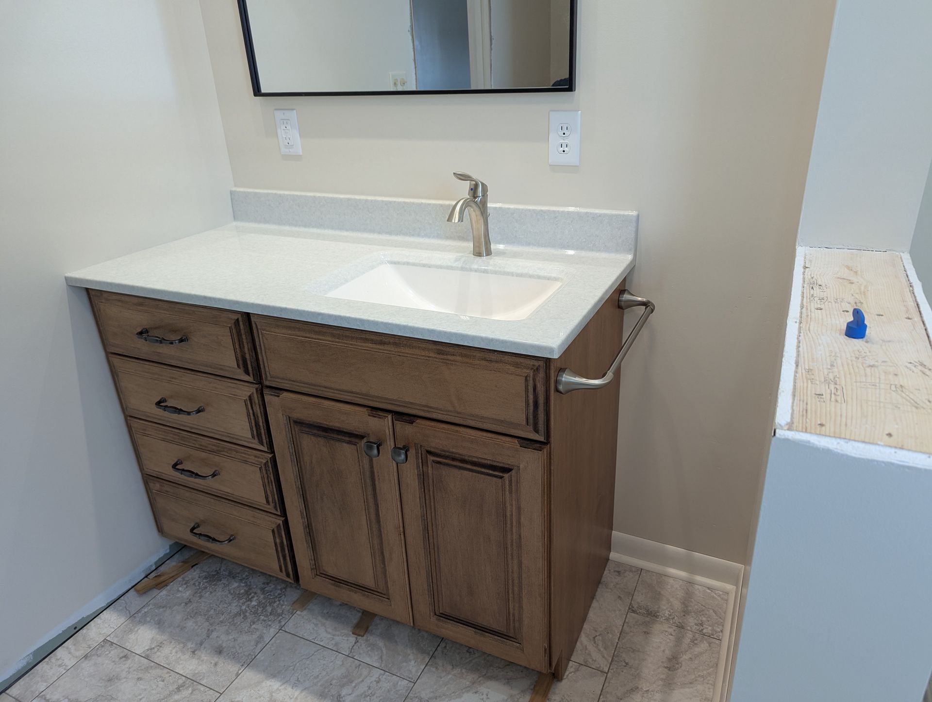 A bathroom vanity with a sink, mirror and drawers.