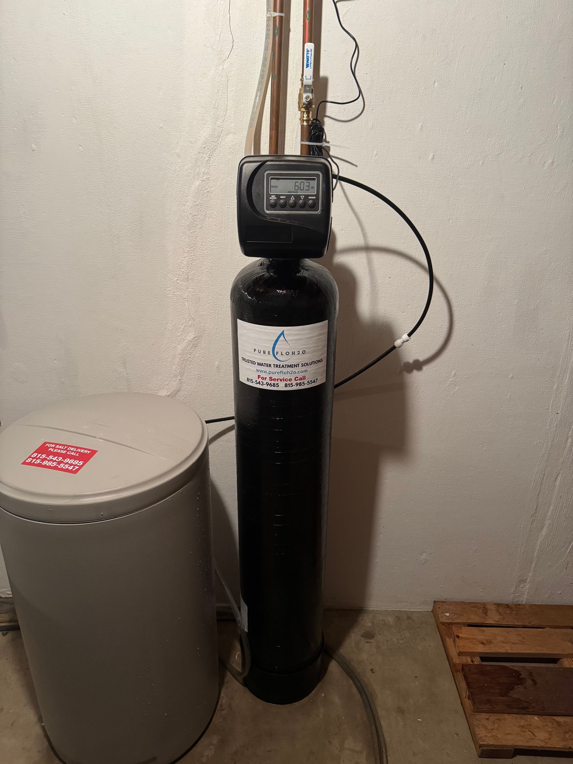 Water softener system with a tall black tank, digital control, and a brine tank.