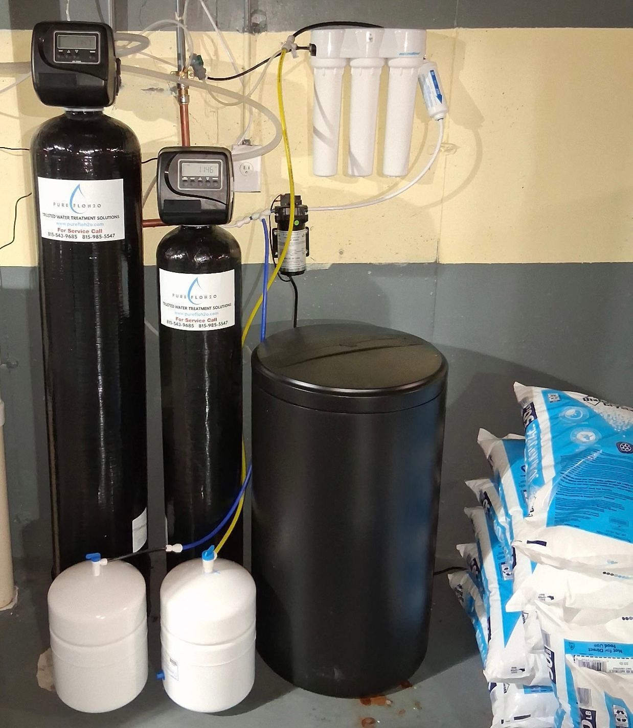Water filtration system with tanks, filters, and salt bags.