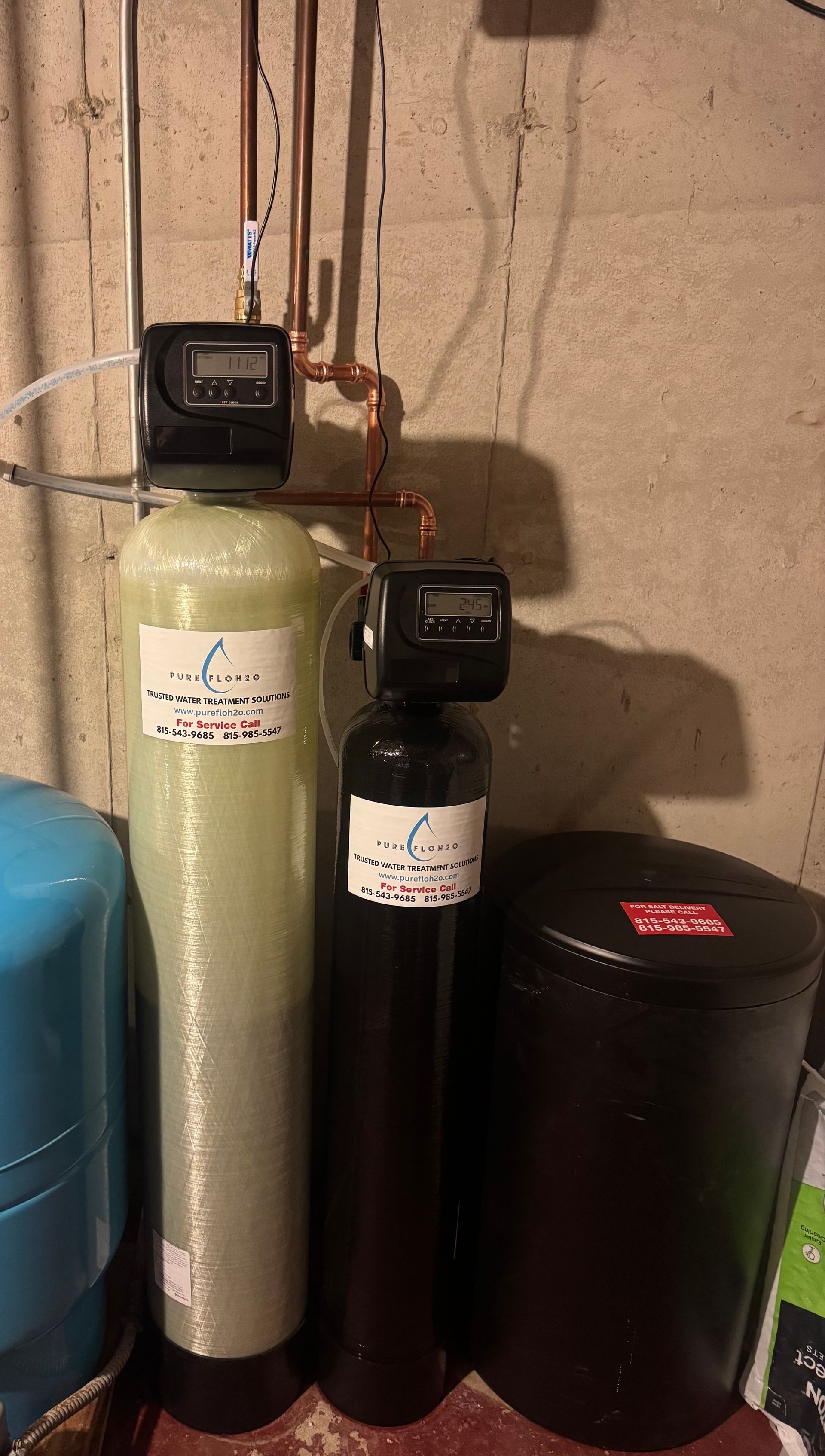 Water filtration and softening system in a basement setting includes two tanks and a salt storage container.
