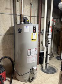 Three cylindrical water heaters and HVAC equipment in a utility room.