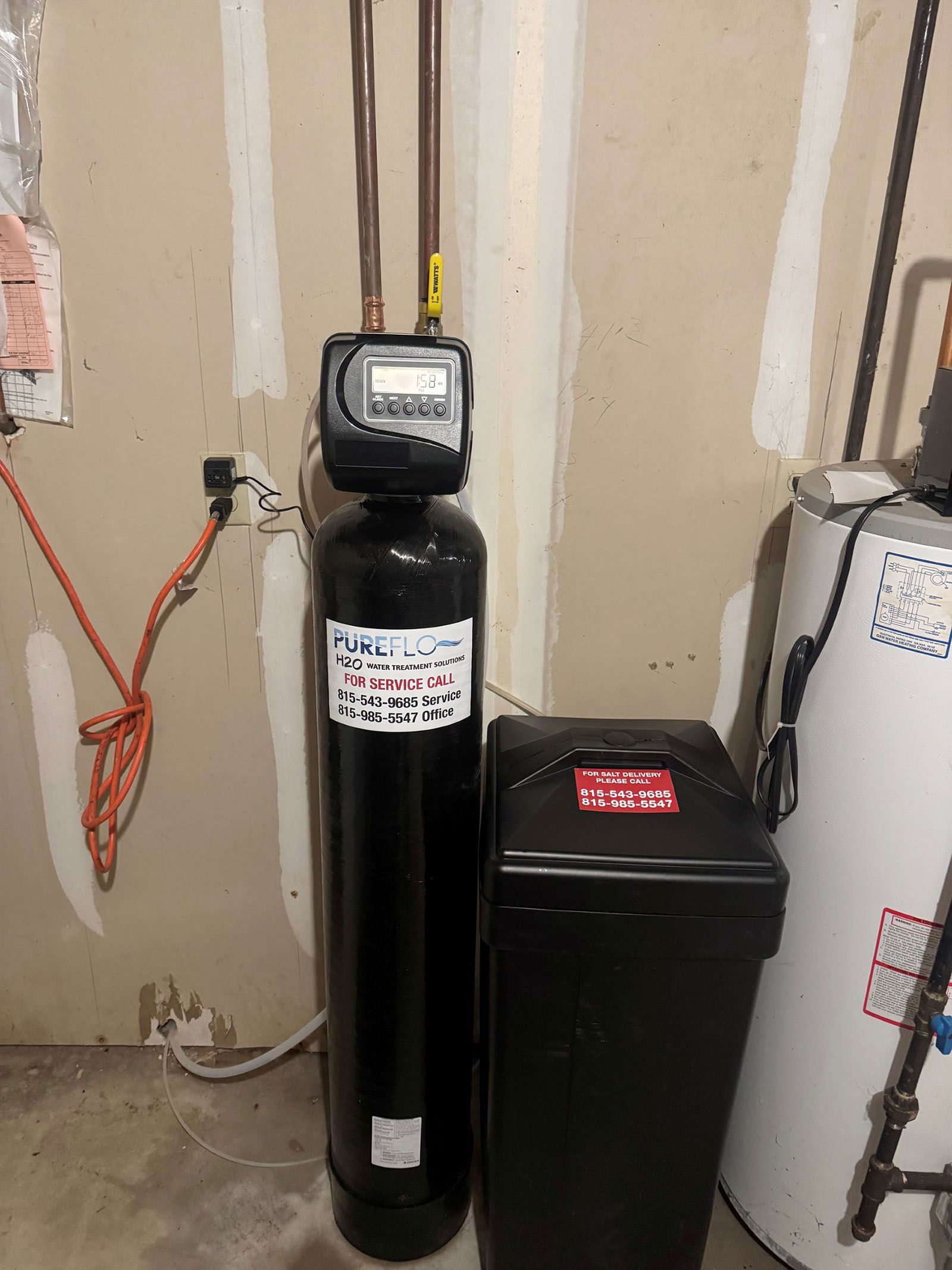 White salt pellets fill a water softener's tank. A yellow-filled cylinder is visible.