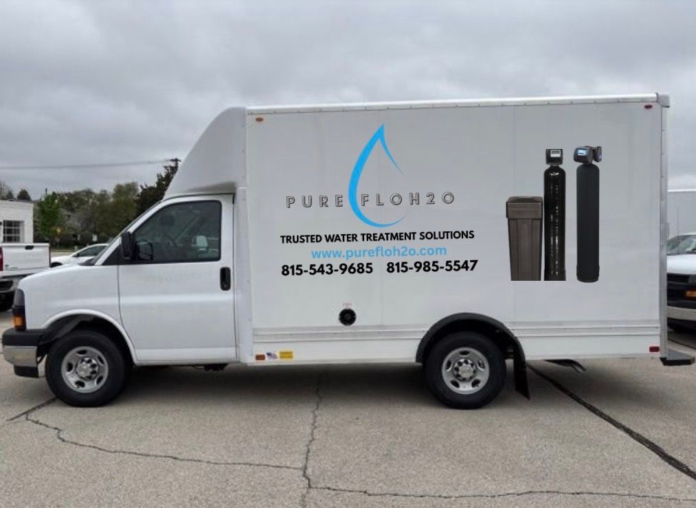 White truck with "Pure Flow 815" logo, water treatment equipment. Phone numbers on side.