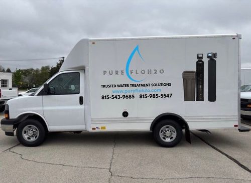 White truck with "Pure Flow 815" logo, water treatment equipment. Phone numbers on side.