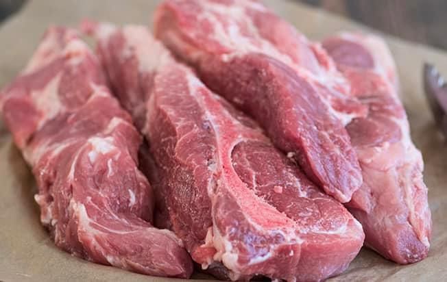 A pile of raw meat is sitting on a piece of paper.