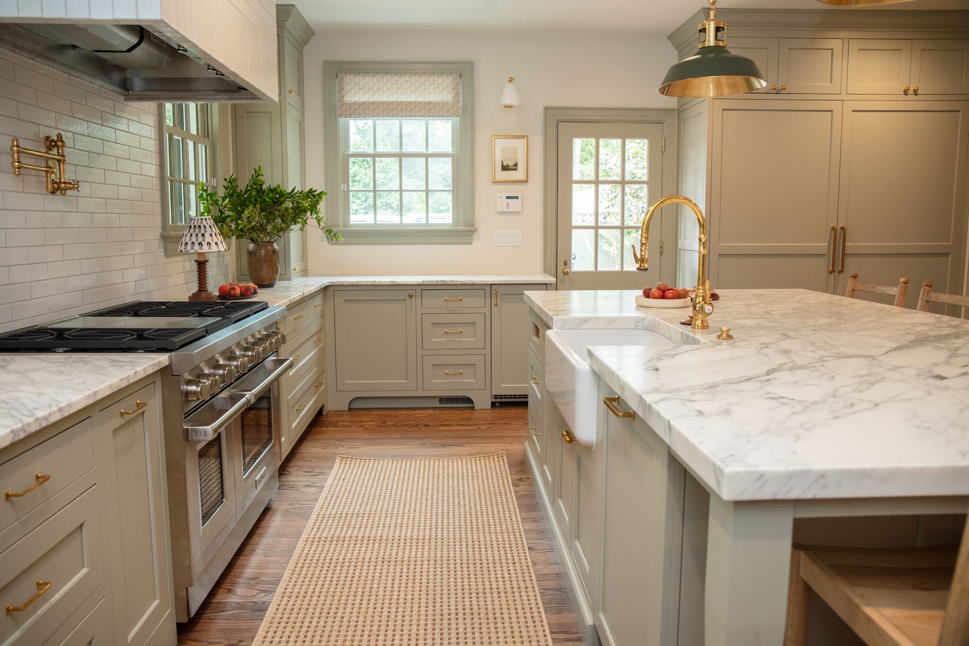 A kitchen with a large island and marble counter tops.