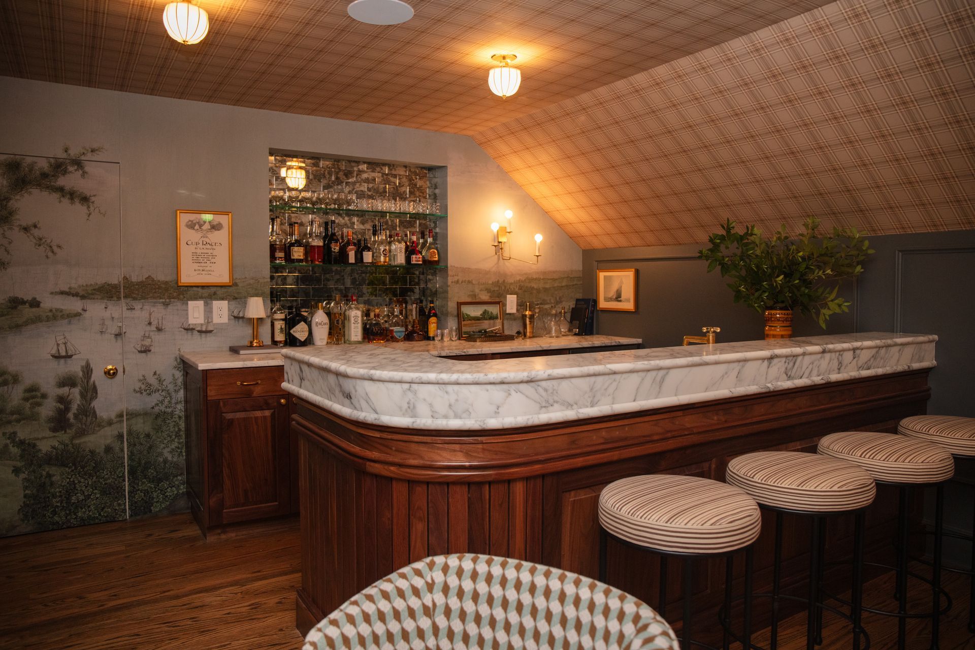 A bar with a marble counter top and stools in a room.