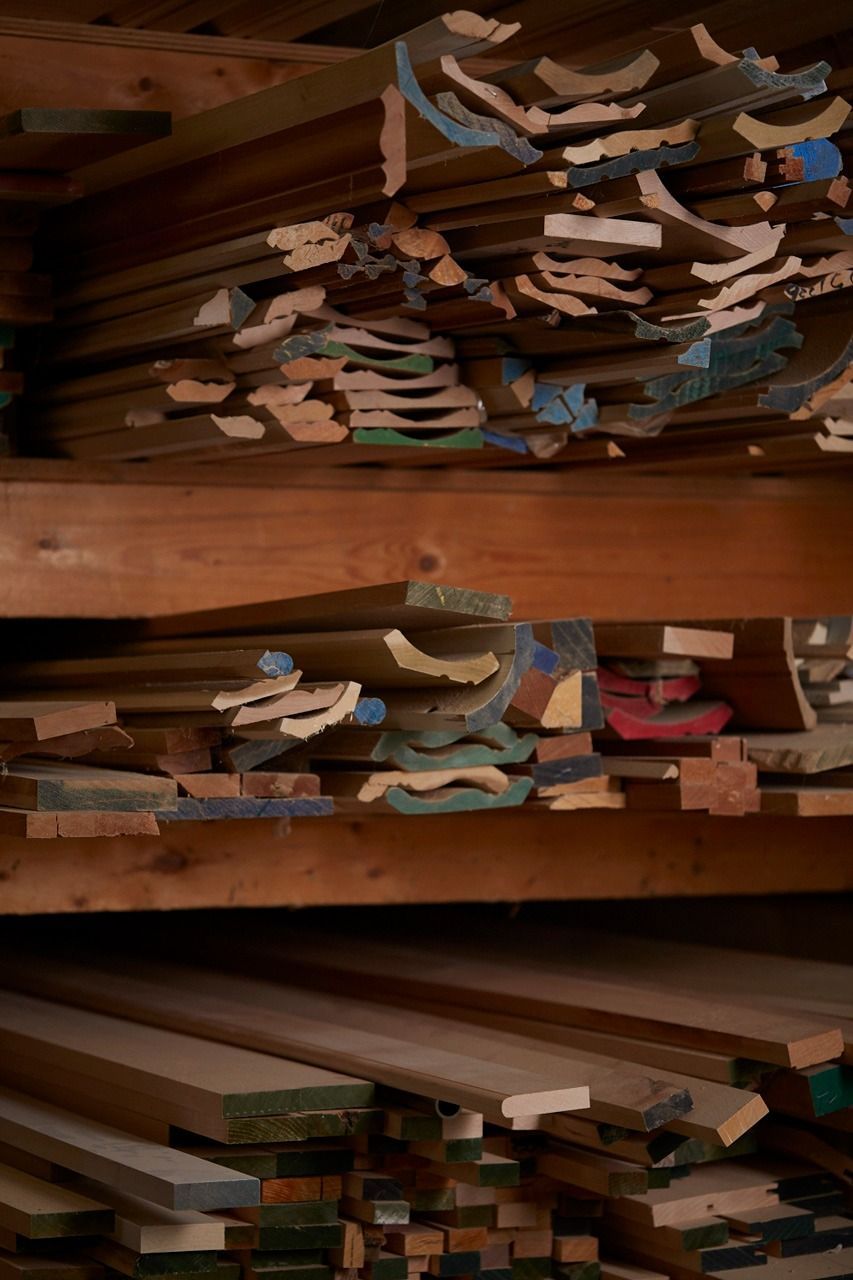Shelves stacked with various wood pieces in a lumberyard; different shapes, sizes, and some painted edges.