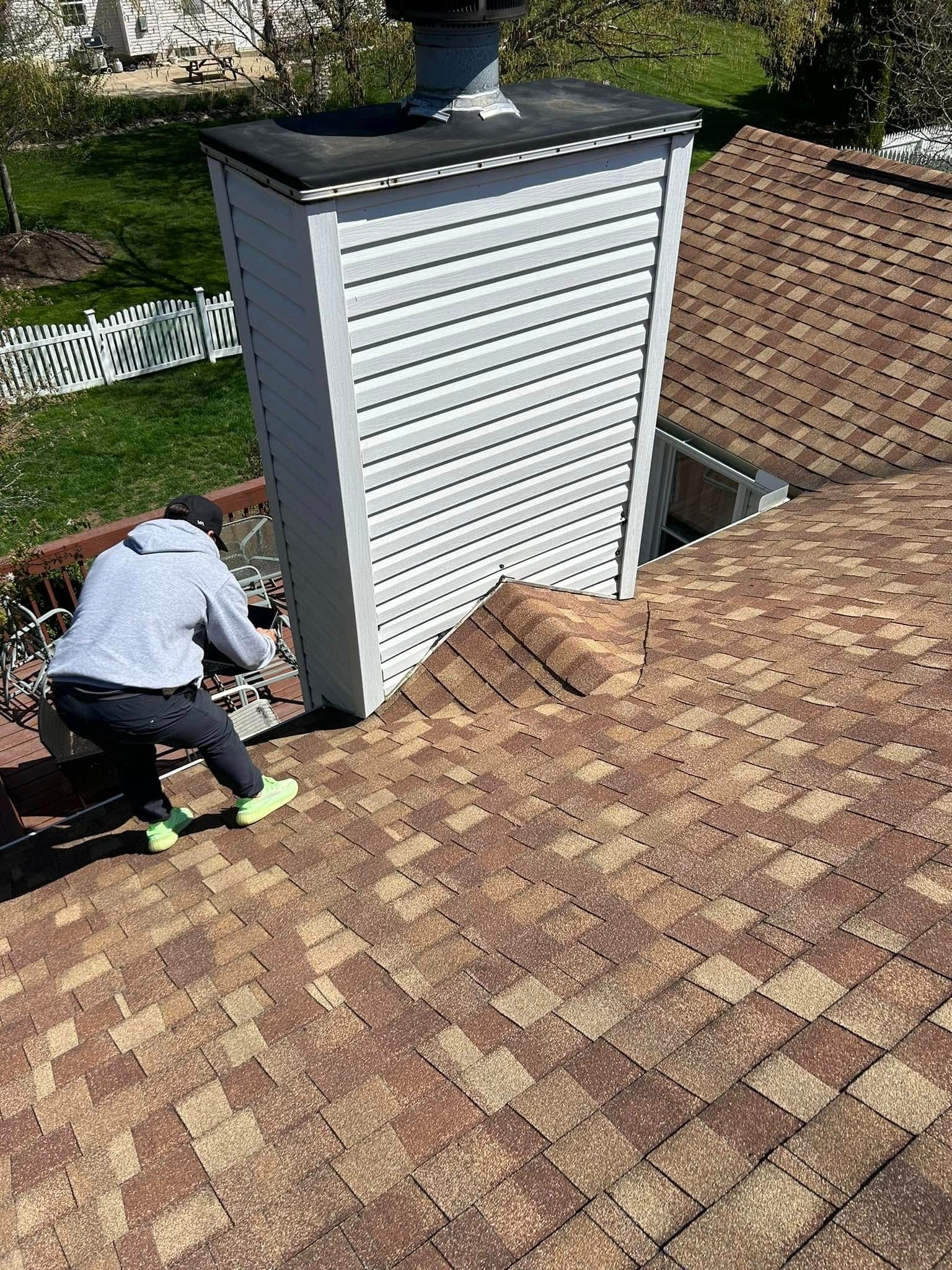Person on a roof near a chimney. They appear to be working.