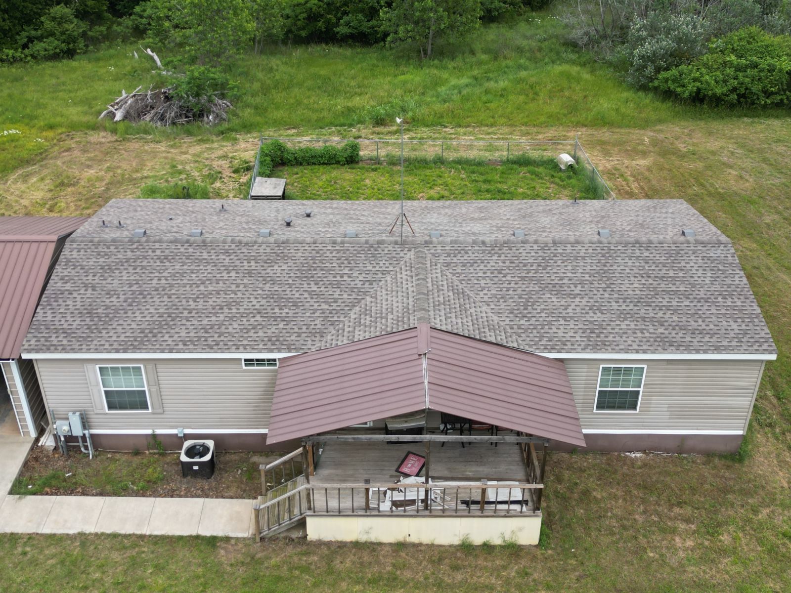 An aerial view of a mobile home with a covered porch.