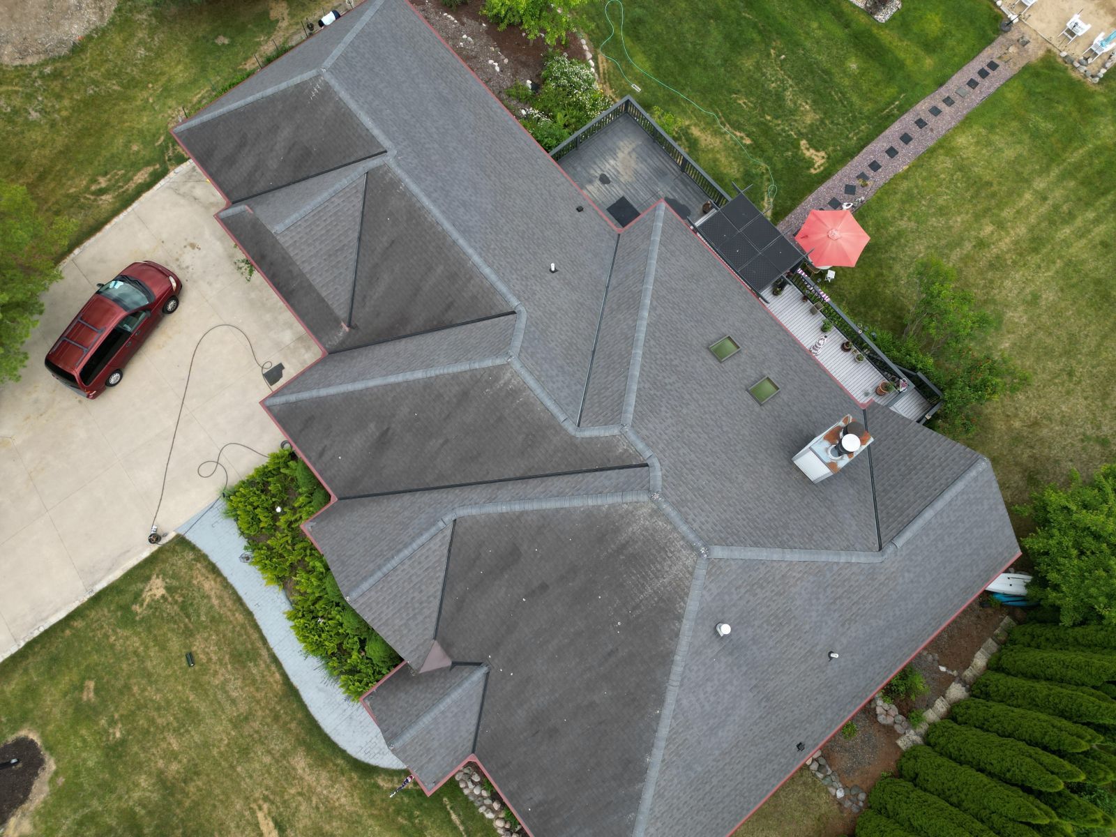An aerial view of a house with a car parked in the driveway
