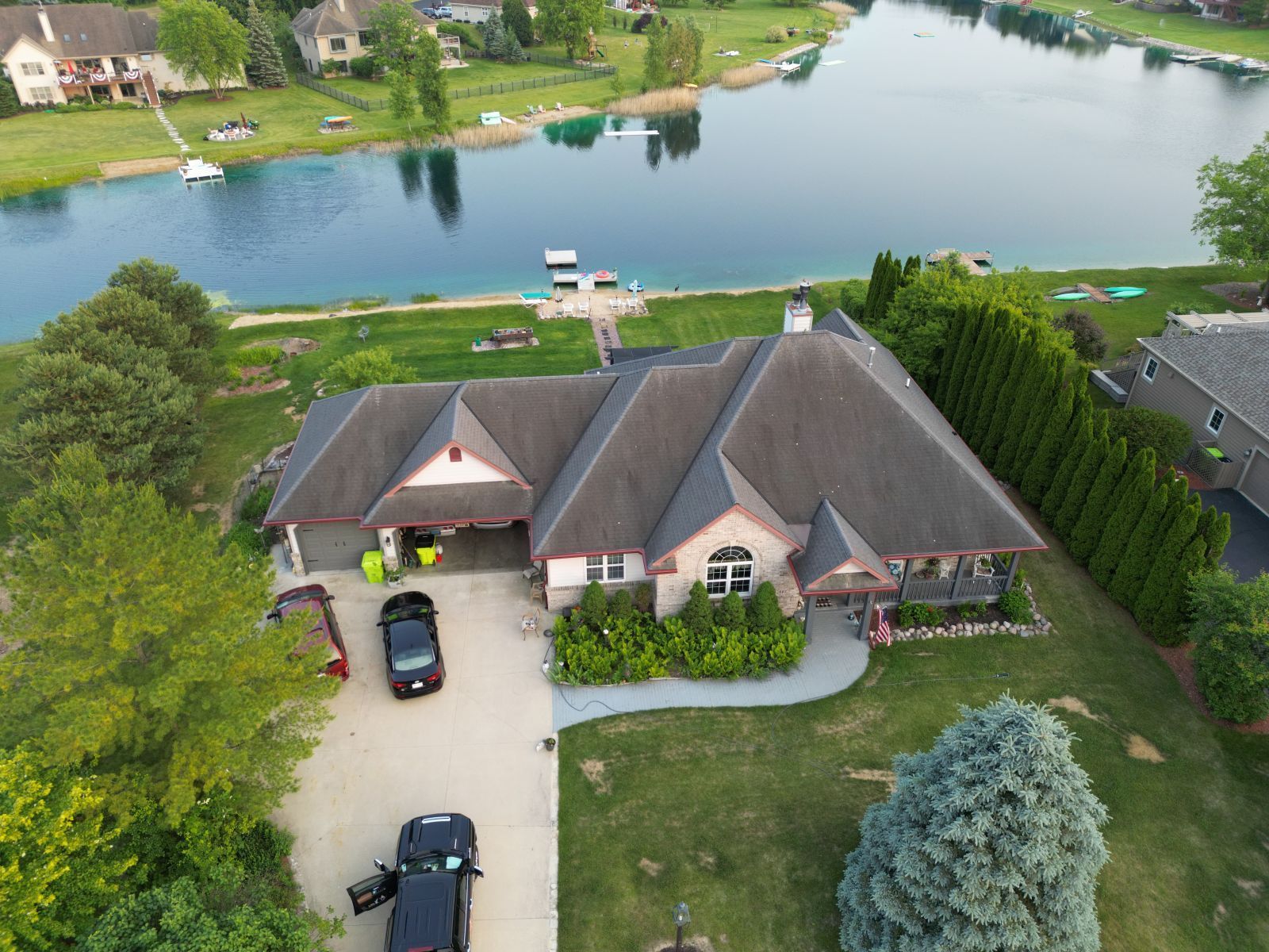 An aerial view of a house with a lake in the background