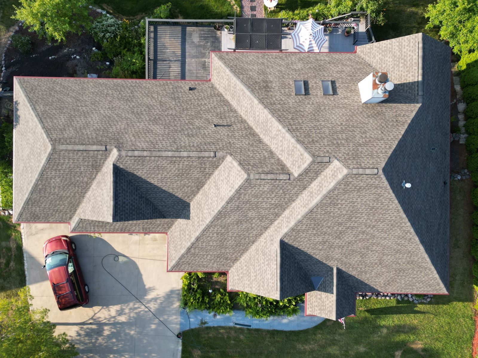 An aerial view of a house with a car parked in the driveway.