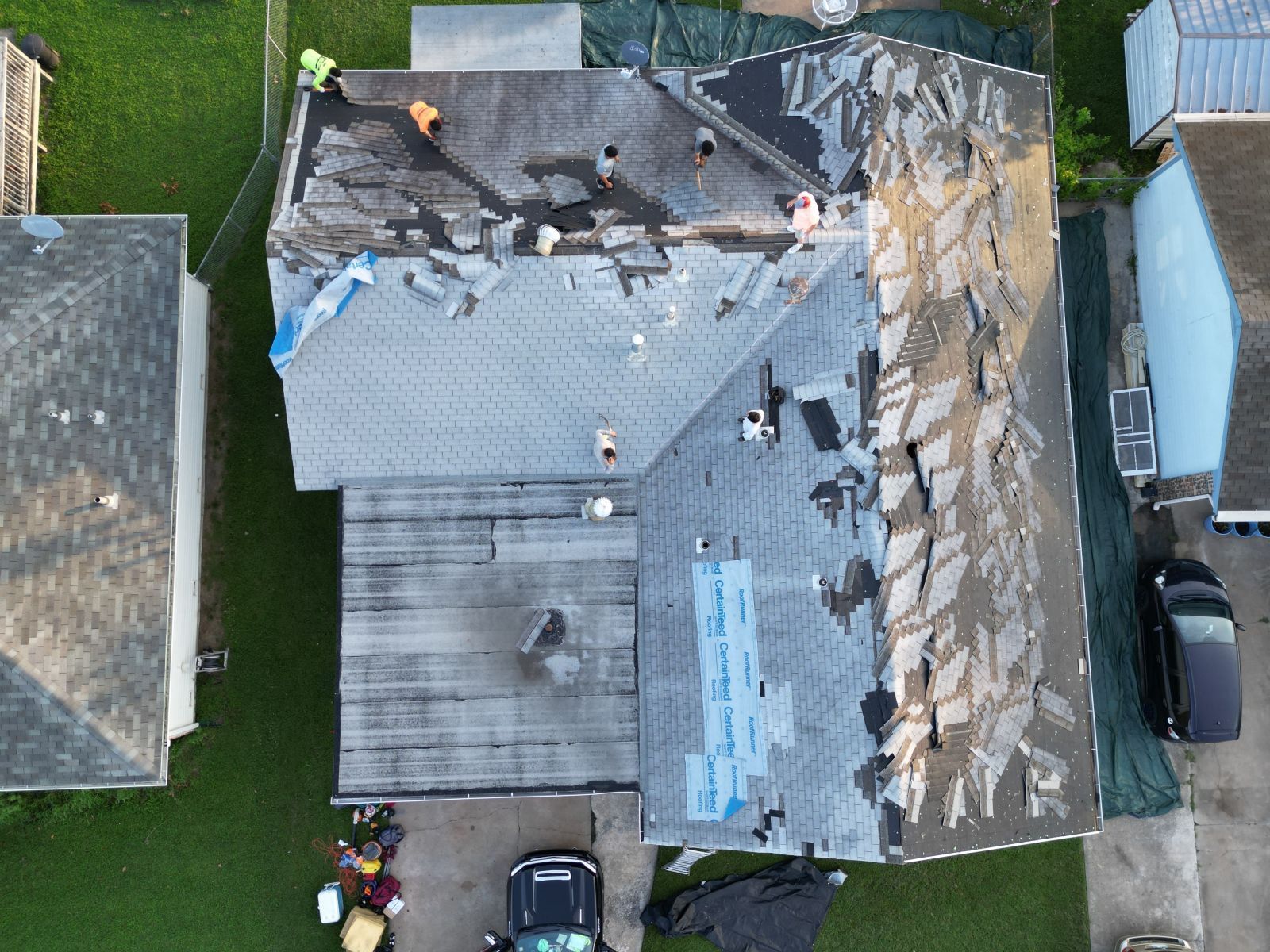 An aerial view of a house with a roof being repaired.