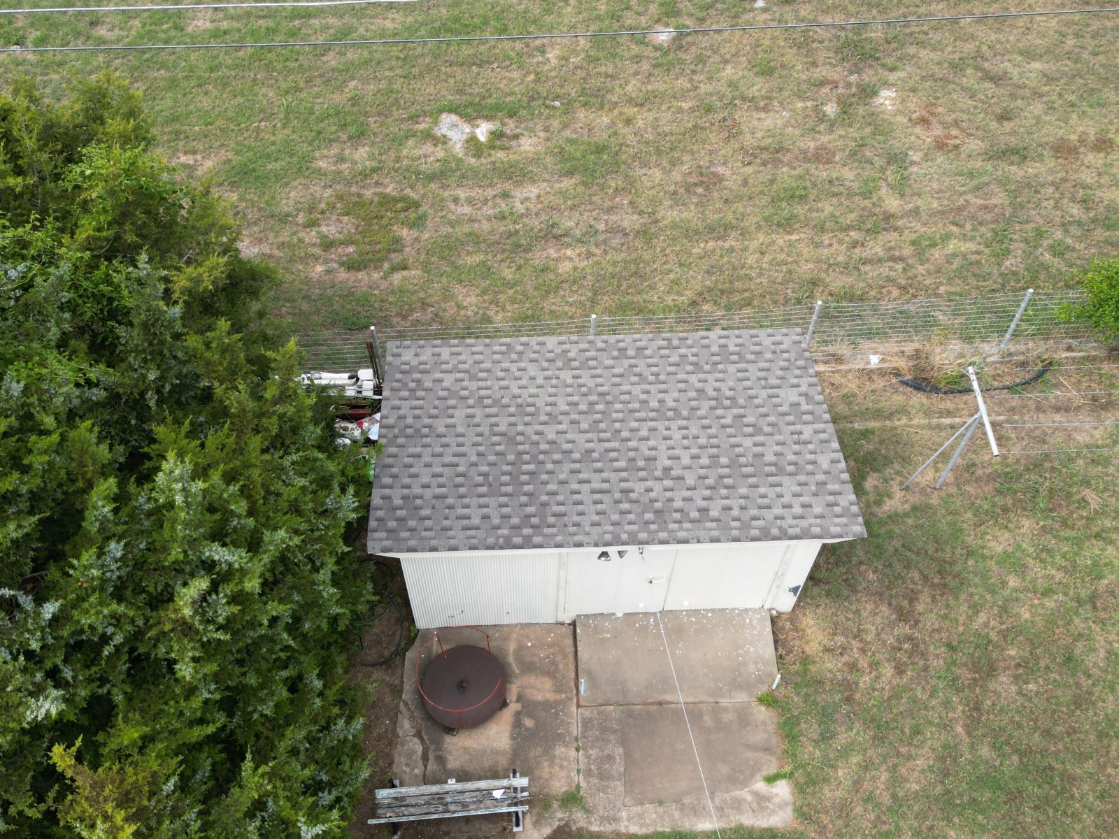 An aerial view of a shed in the middle of a field.