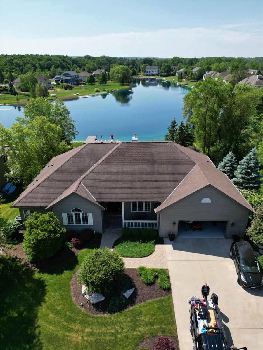 An aerial view of a house with a lake in the background.