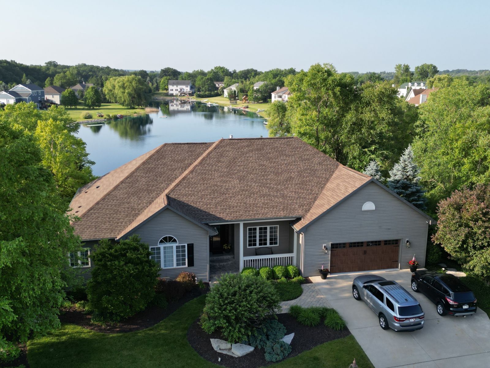An aerial view of a house with a lake in the background
