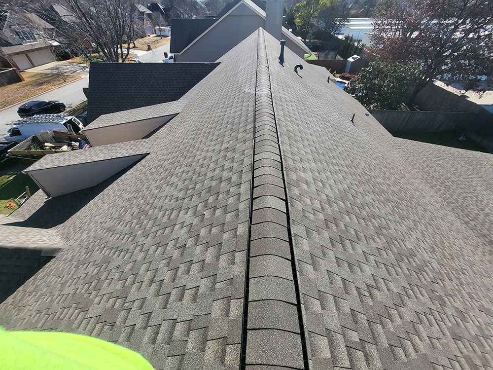 A person is standing on the roof of a house.