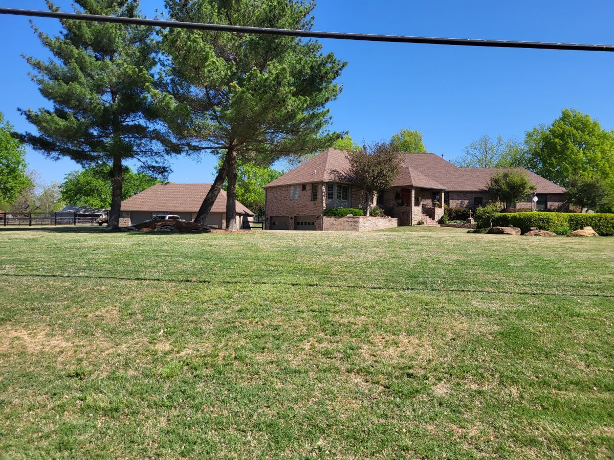 A house sits in the middle of a lush green field