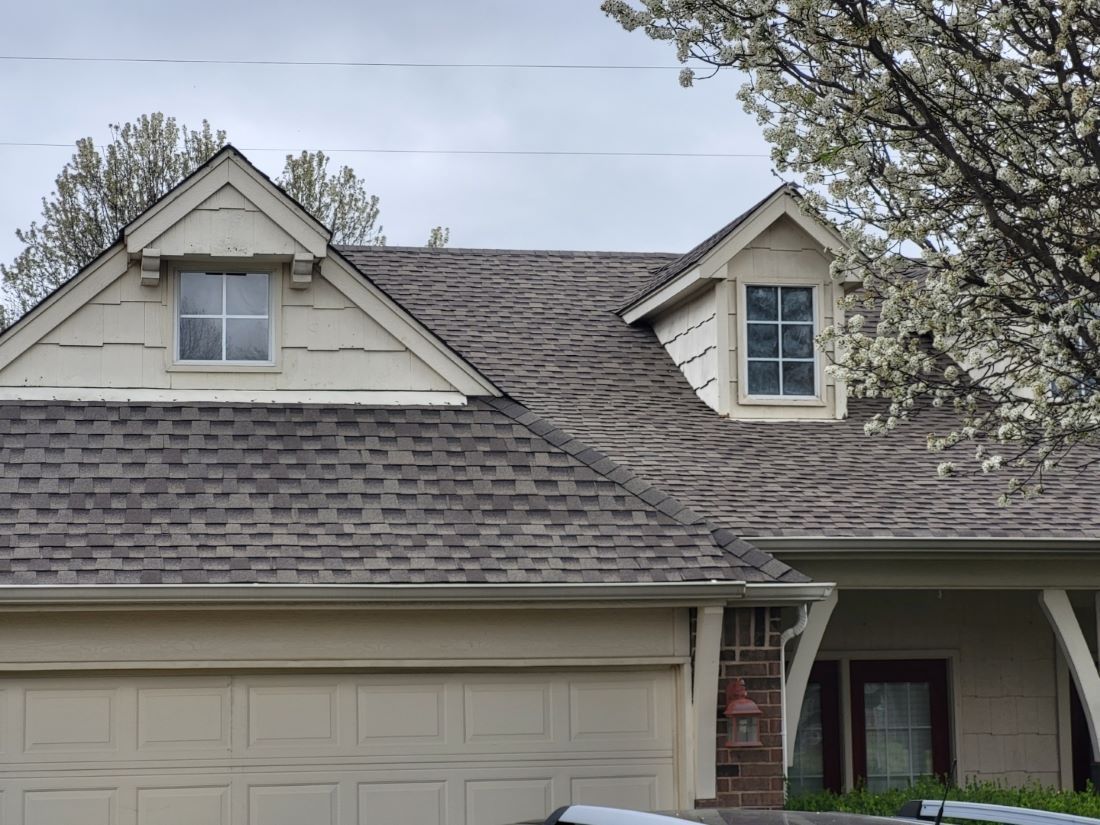 A house with a gray roof and a garage door
