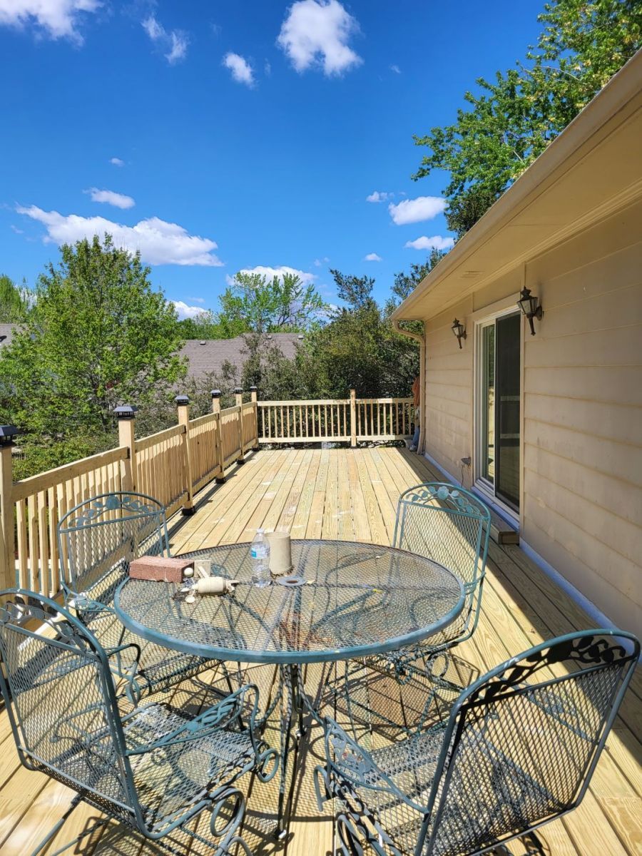A wooden deck with a table and chairs on it