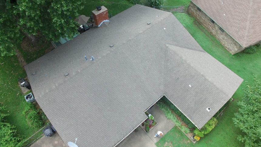 An aerial view of a house with a roof that is being repaired.