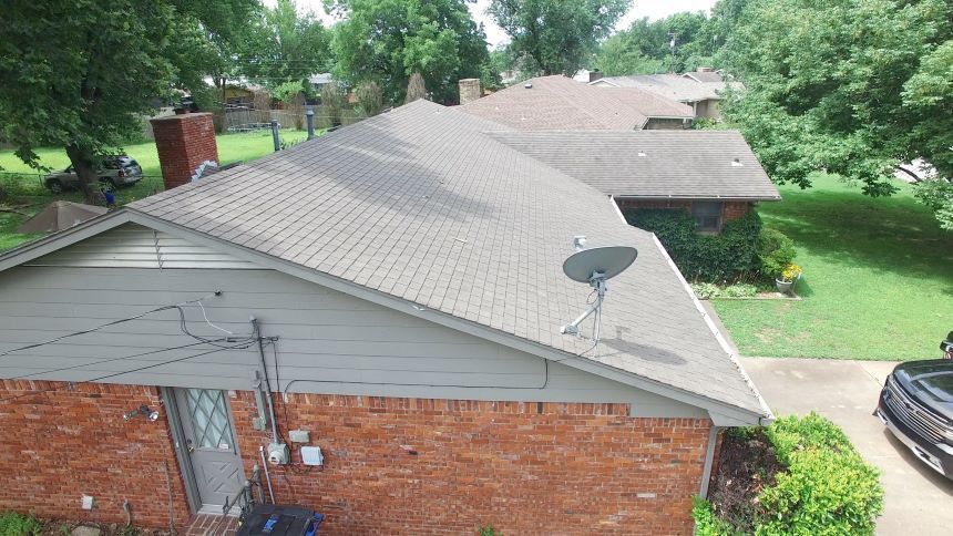 An aerial view of a house with a satellite dish on the roof.