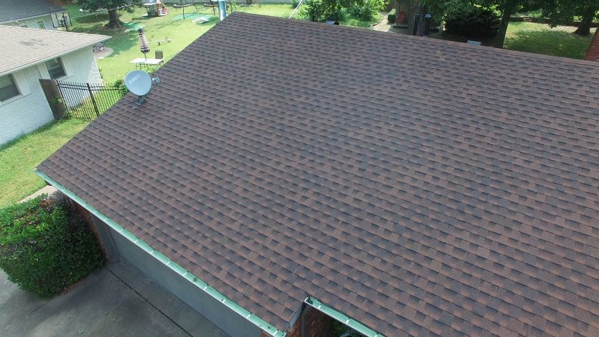 An aerial view of a house with a satellite dish on the roof.