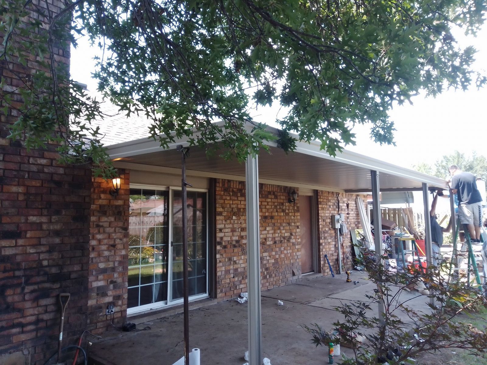 A brick house with a covered patio in front of it