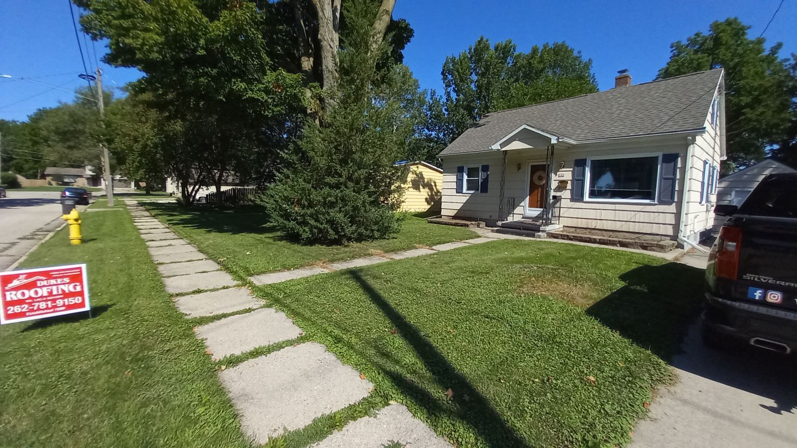 A house with a for sale sign in front of it.