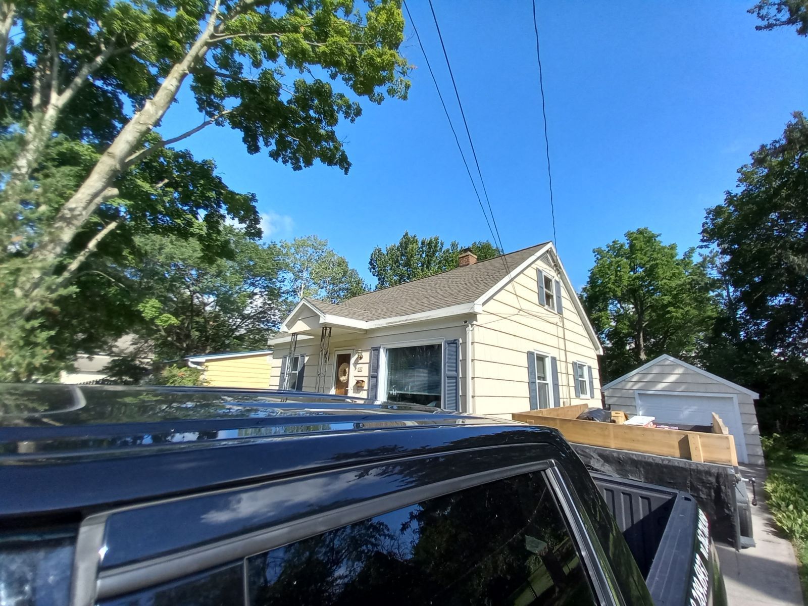 A car is parked in front of a house on a sunny day
