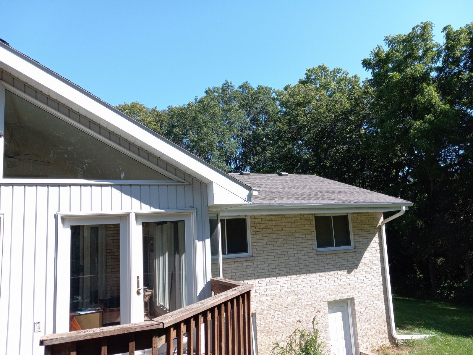 A house with a deck and trees in the background
