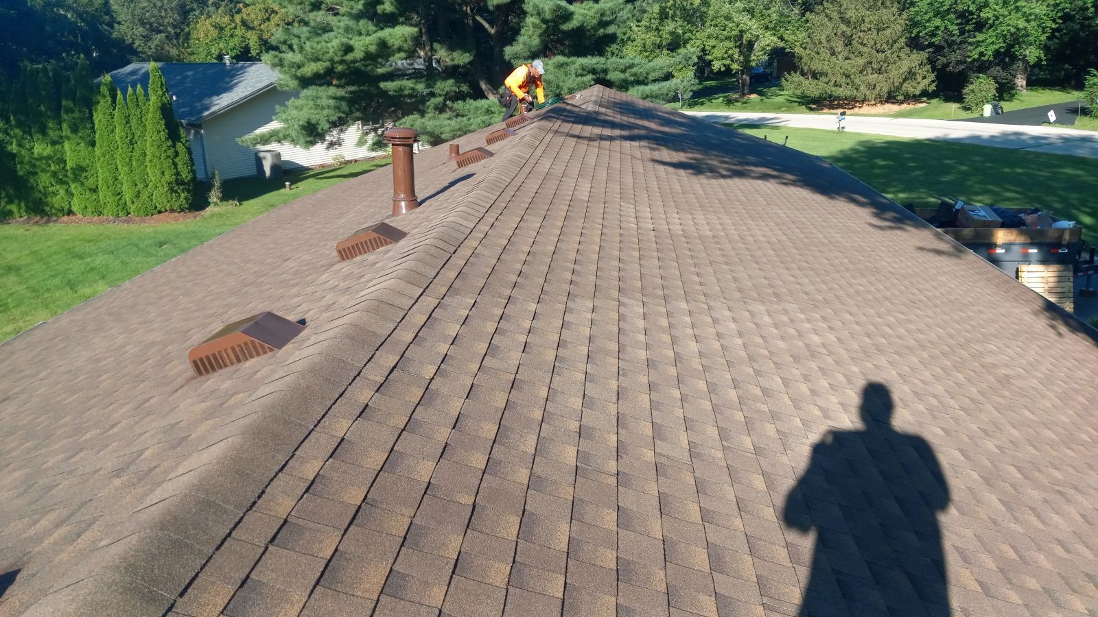 A man is working on the roof of a house.